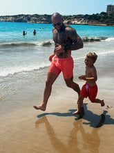 Man and boy running on a beach wearing Thirsty Threads Burnt Horizon Hybrid boardshorts