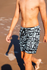 Boy wearing Mint Geo quick dry 4-way stretch boardshorts with built-in Hybrid anti-chafe liner at the beach