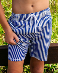 Boy wearing Pacific Stripe quick dry 4-way stretch boardshorts with built-in Hybrid anti-chafe liner outdoors